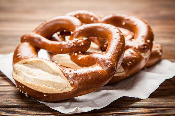pretzels en mesa de madera - pretzel snack salty food fotografías e imágenes de stock
