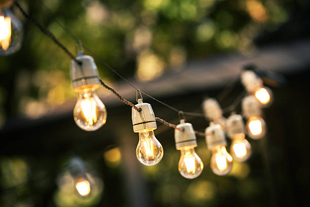 outdoor string lights hanging on a line in backyard outdoor string lights hanging on a line in backyard light bulb filament photos stock pictures, royalty-free photos & images