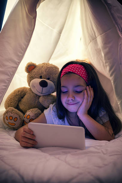 istock Little Girl Using Digital Tablet in Bed 611885794