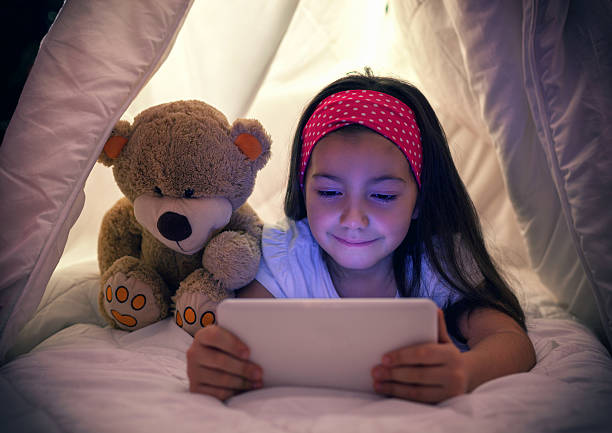 istock Little Girl Using Digital Tablet in Bed 611885908