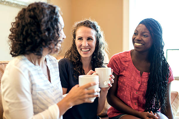 istock Diverse female friends drinking tea and laughing together 611886554