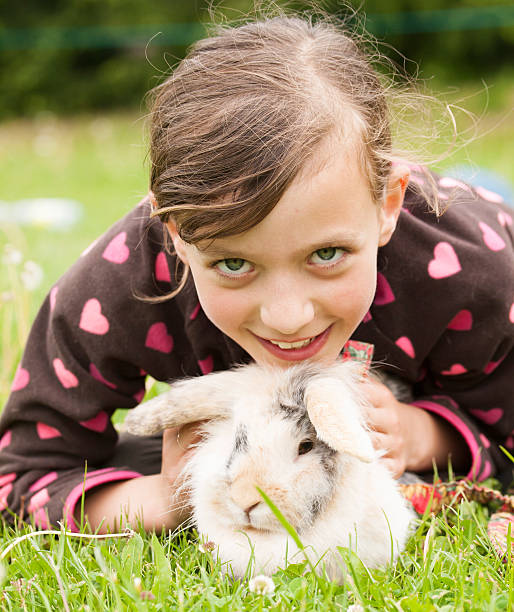 istock Young smiling girl with her rabbit pet 611887946