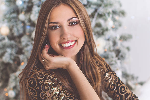 istock Smiling woman in studio near christmas tree 611888262