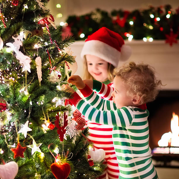 istock Kids decorating Christmas tree in beautiful living room 611888616