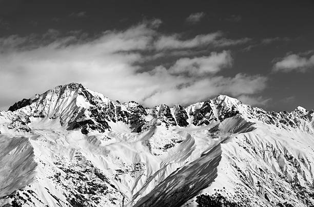istock Black and white snow mountains in winter sun day 611888724