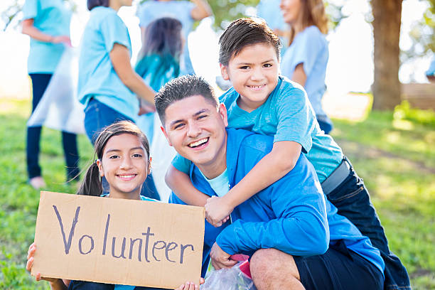 istock Hispanic father and his kids help clean up park 611889172