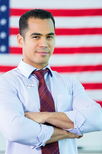 istock Confident Hispanic American in front of American flag 611889388