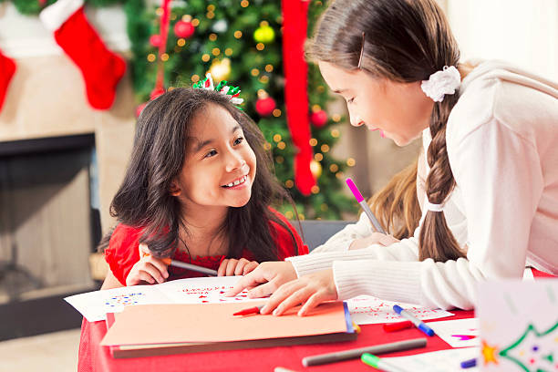 istock Two happy young girls making Christmas cards 611890480