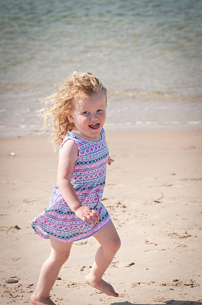 istock Happy girl running on the beach 611891446