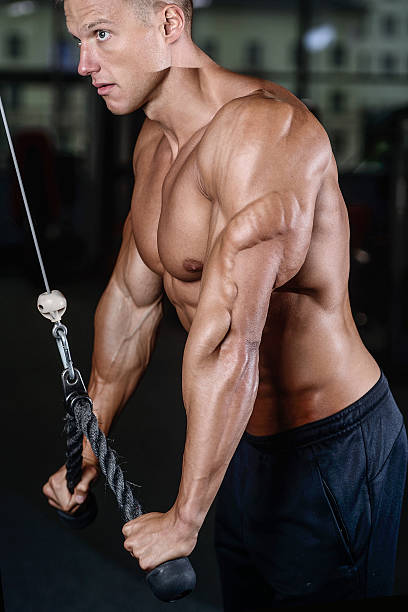 istock Handsome muscular bodybuilder man doing exercises in gym 611892928
