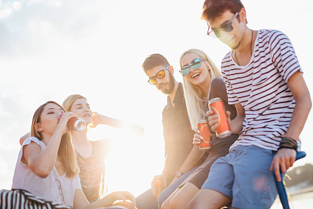 Friends having fun Group of friends drinking and having fun by the river drink can photos stock pictures, royalty-free photos & images