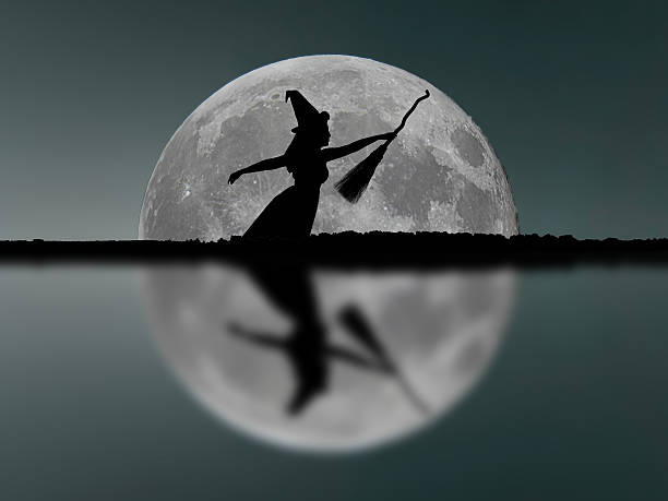 istock Halloween witch silhouette flying with broomstick. Full Moon. Reflection. 611894944