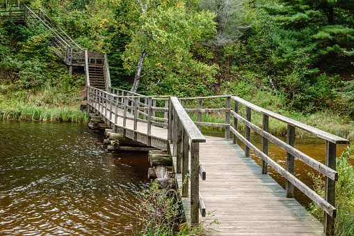 Wooden boardwalk bridge across lagoon in Big Bay Town Park, Madeline Island, Wisconsin, USA, at end of September, for themes of outdoor recreation, tourism and ecology