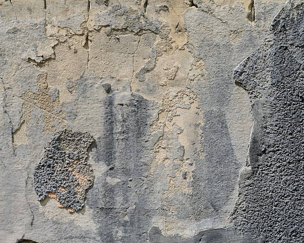 istock Gray plaster weathered wall with stains and cracks 611900056