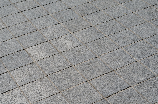 Gray tiles of street pavement, city sidewalk