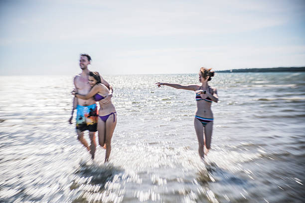 The summer scene at Signing Sands Beach at the Lake Huron, Ontario, Canada. The group of young people, friends, swimming.