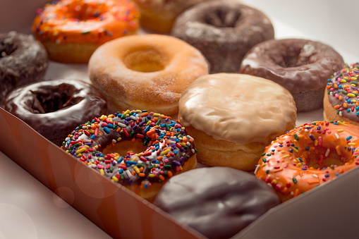 Una docena de donuts vidriados en una caja photo