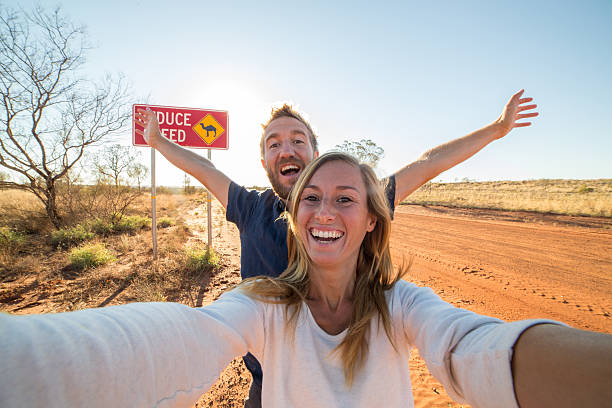 Selfie of young couple standing by Camel warning sign
