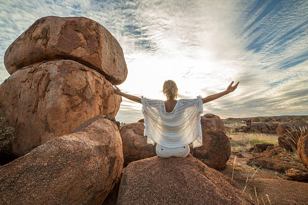istock Young woman relaxing on boulder at sunset 611986784