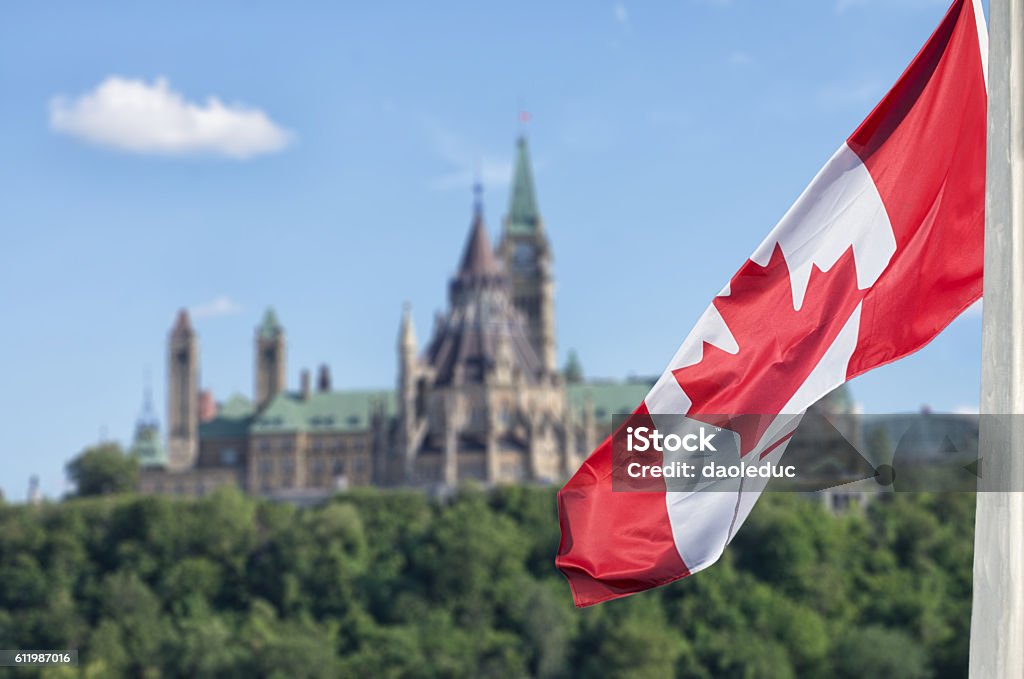 Bandiera canadese che sventola con la collina e la biblioteca del Parlamento Buildings - Foto stock royalty-free di Canada