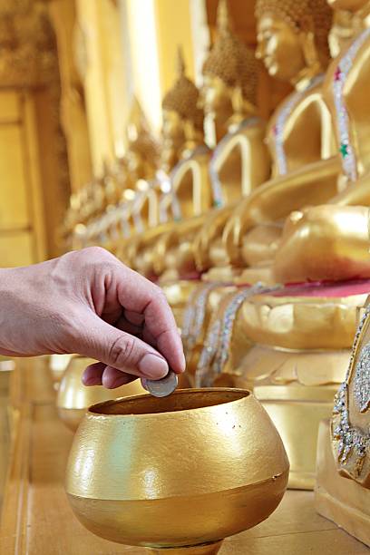 istock Give coin in alms bowl 611988696