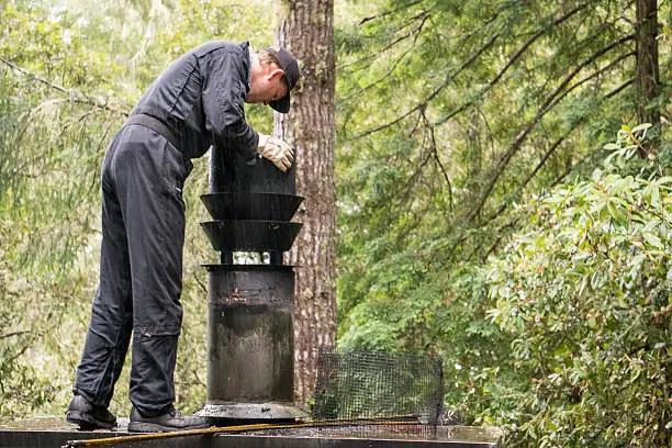 Chimney Sweep cleaning  on roof of house cleaning dirty chimney