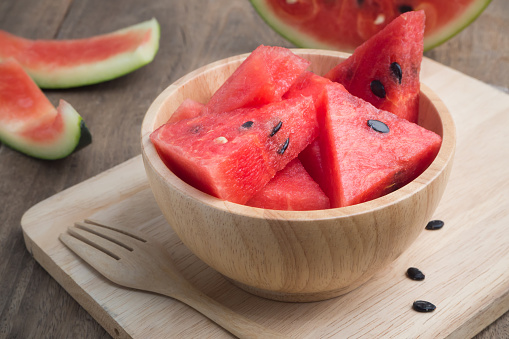 Kitchen table with Sliced of watermelon on wood dish. Red tropical fruit, Red tropical fruit.