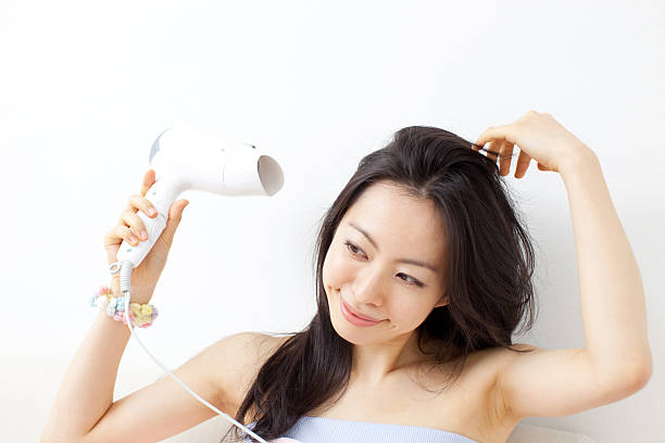 Woman drying her hair stock photo