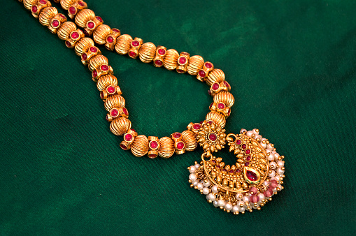 An expensive and embroidered necklace made of white gold on the woman's neck.