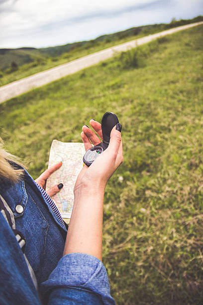 istock Young girl in casual clothes looking down at compass, 612000148