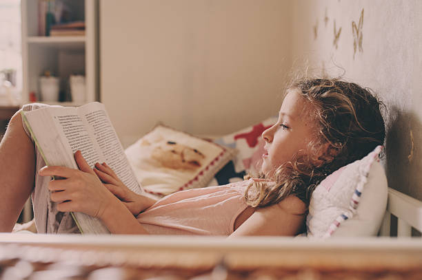 istock kid girl reading book in her room 612000822