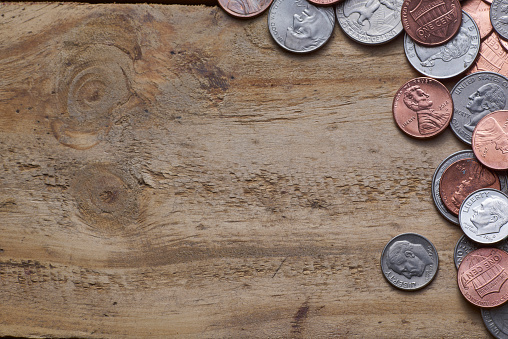 Top view coins on old wooden desk with copy space on top.