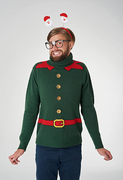 Cheerful man in Christmas jumper Cheerful man in Christmas jumper christmas nerd sweater cardigan stock pictures, royalty-free photos & images