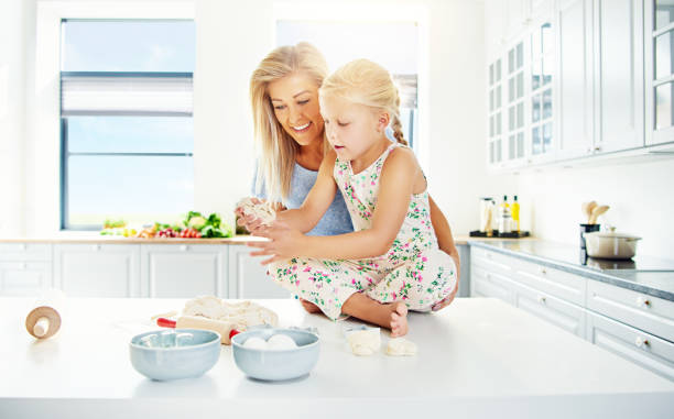 istock Woman helping child with bread dough 612006782