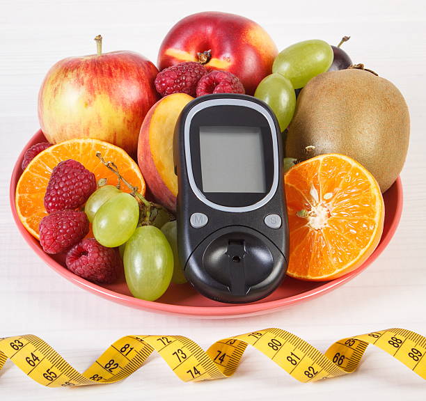 istock Glucometer, fresh fruits on plate and centimeter, diabetes 612006880