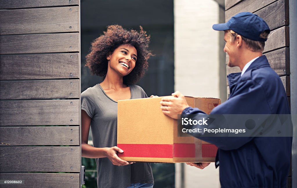 Skip the queues & traffic jams Shot of a courier making a delivery to a smiling customer Package Stock Photo