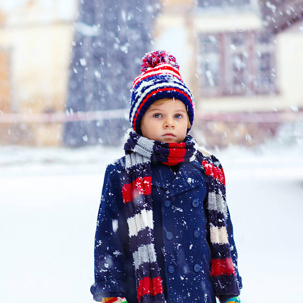 istock Happy kid boy having fun with snow in winter 612009280