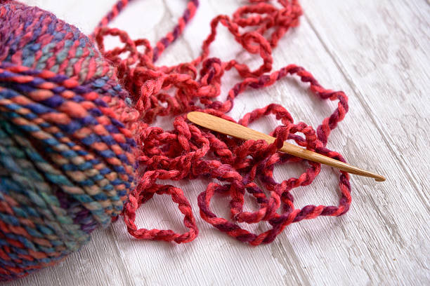 ball of purple yarn and Crochet hook stock photo
