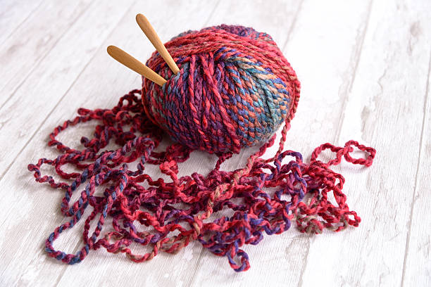 ball of purple yarn and knitting needles stock photo