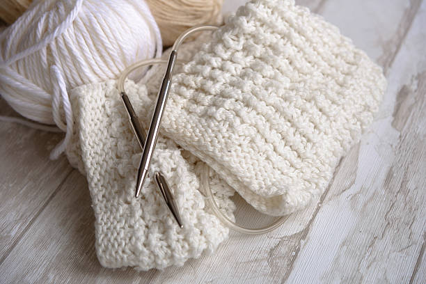 white and beige balls of yarn and knitting needles stock photo