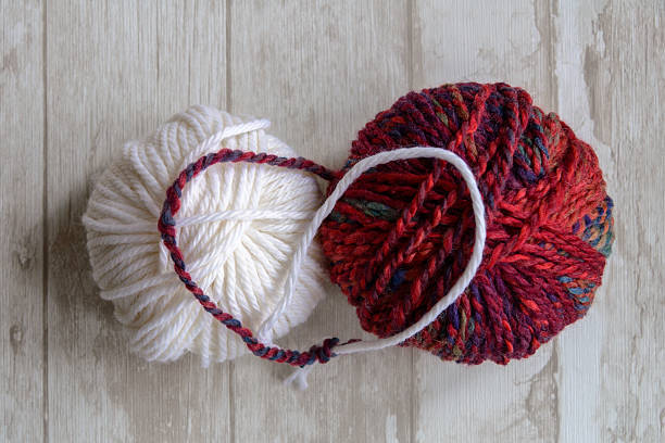 white and purple balls of yarn connected stock photo