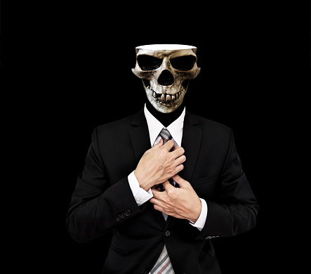 Businessman in black suit with ckull opening, on black background