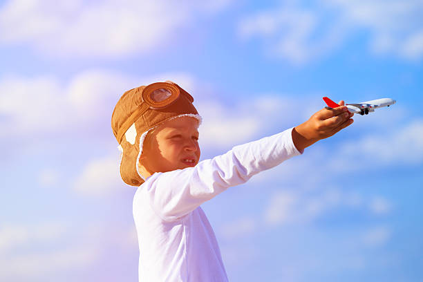 istock Happy kid playing with toy airplane on blue sky 612012622