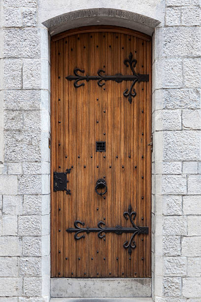 istock thick ornate old door with ironwork in sandstone wall 612012692