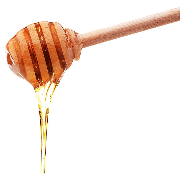 istock Honey dripping from a wooden honey dipper 612013548