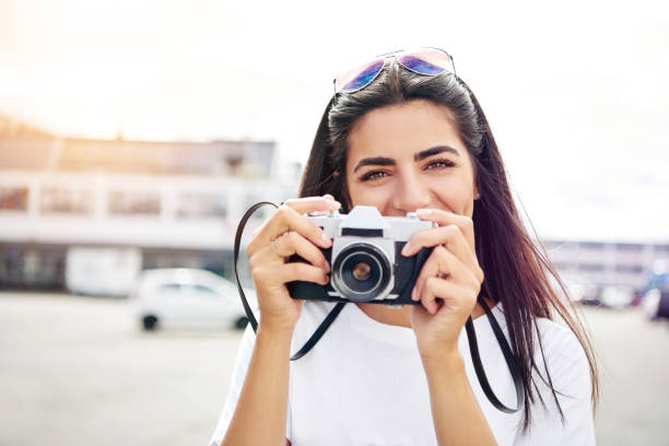 istock Smiling happy female tourist with a camera 612014224
