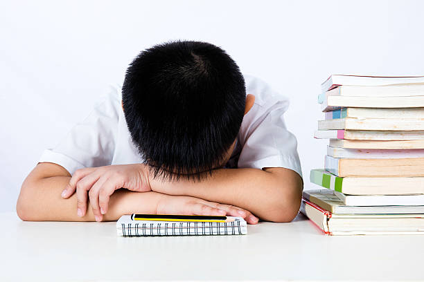istock Asian Chinese Little Boy Wearing Student Uniform Sleeping on Des 612015742
