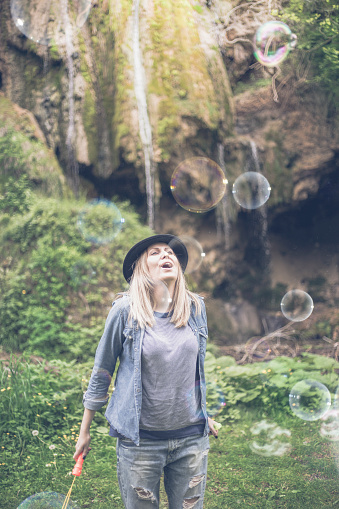 beautiful woman blowing bubbles toned with a retro vintage instagram filter