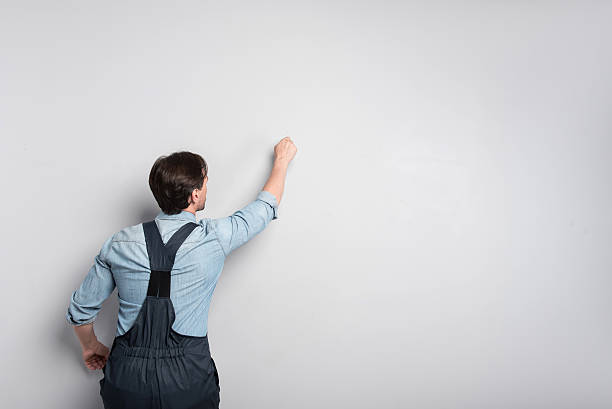 istock senior concentrated man writing on the wall. 612017002