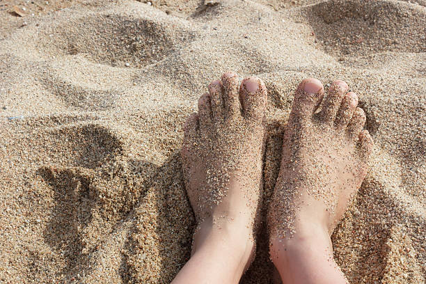 istock Bare feet in the sand on beach 612019350